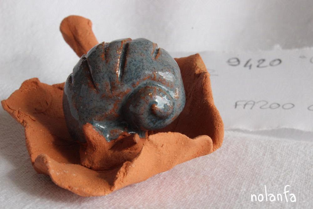 grey-glazed snail on red clay