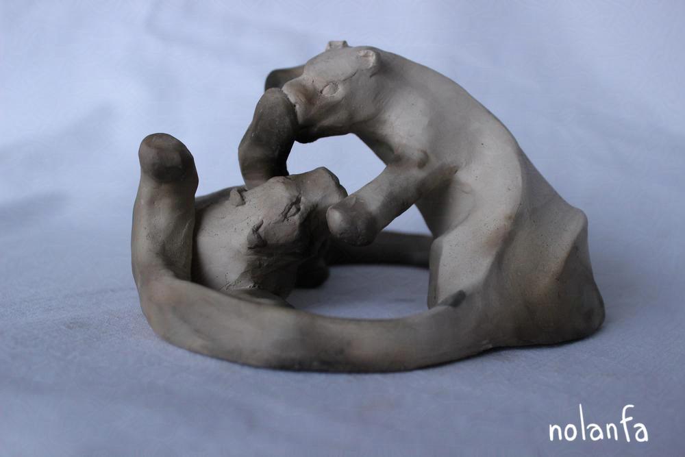 one sculpture of two snoleos, playing, one bopping the other's nose